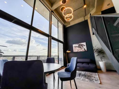 a room with a table and chairs and a large window at Skyline Suites - Elegant Living with Coworking & Scenic Views in Bogotá
