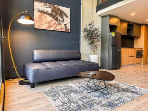 a living room with a couch and a table at Skyline Suites - Elegant Living with Coworking & Scenic Views in Bogotá