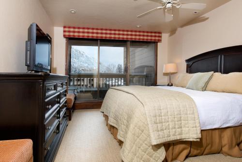 a bedroom with a bed and a tv and a window at The Gant in Aspen