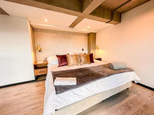 a bedroom with a large bed in a room at Skyline Suites - Elegant Living with Coworking & Scenic Views in Bogotá