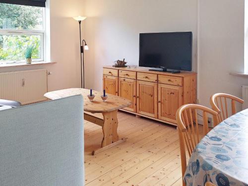a living room with a table and a television at 4 person holiday home in Ålbæk-By Traum in Ålbæk