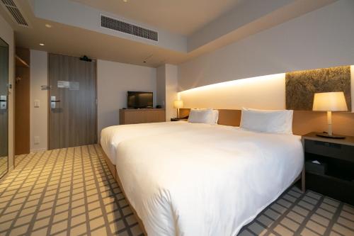 a large white bed in a hotel room at THE GENERAL KYOTO Shijou Shinmachi in Kyoto