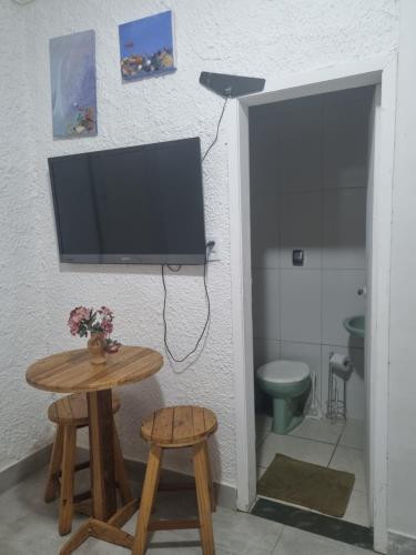 een badkamer met een tv en een tafel met krukje bij Quarto verde Asa Sul in Brasilia