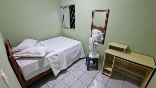 a small bedroom with a bed and a mirror at Apartamento da Tia Jaci in Paulista