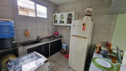 a kitchen with a white refrigerator and a sink at Apartamento da Tia Jaci in Paulista