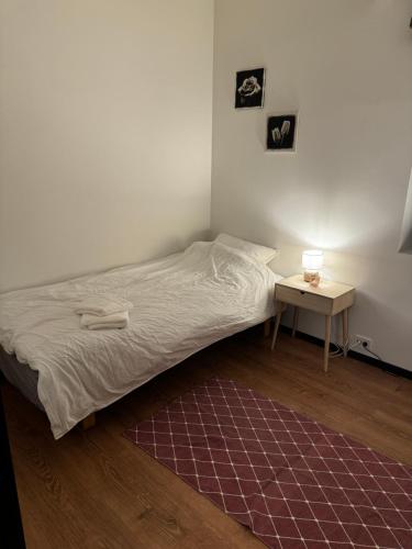 a small bedroom with a bed and a table at Gammelgårdvegen 31 in Tromsø