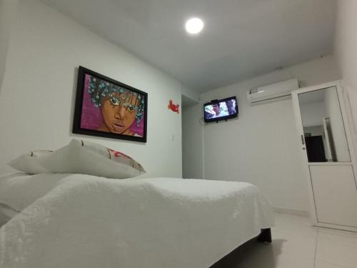 a bedroom with a bed and a tv on the wall at Hospedaje Belleza Isleña habitaciones Individuales in San Andrés