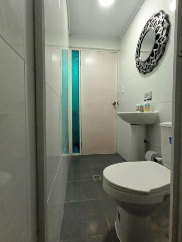 a bathroom with a toilet and a sink and a mirror at Hospedaje Belleza Isleña habitaciones Individuales in San Andrés
