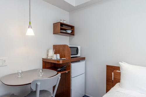 a small room with a small table and a small kitchen at Tokyu Stay Ikebukuro in Tokyo