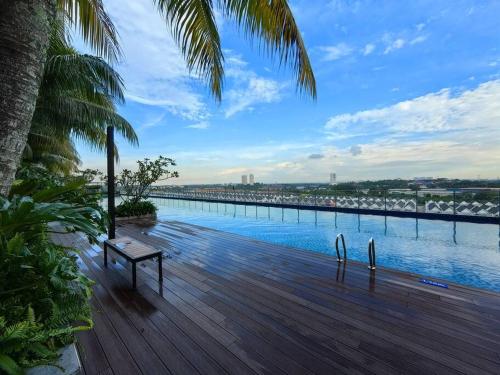 a wooden deck with a bench and a view of the water at Midas Seri Alam 1BR, 1-4 pax in Masai