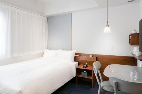 a bedroom with a bed and a table and a chair at Tokyu Stay Ikebukuro in Tokyo