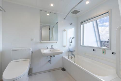 a white bathroom with a toilet and a sink at Tokyu Stay Ikebukuro in Tokyo