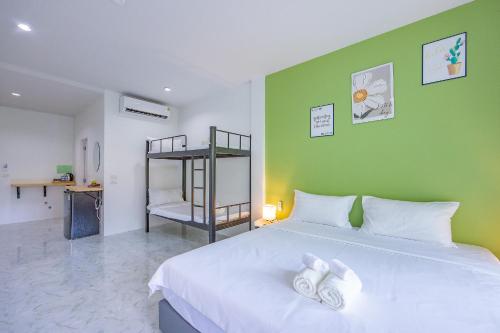 a bedroom with a white bed and a green wall at Karon Hotel at 22 in Karon Beach