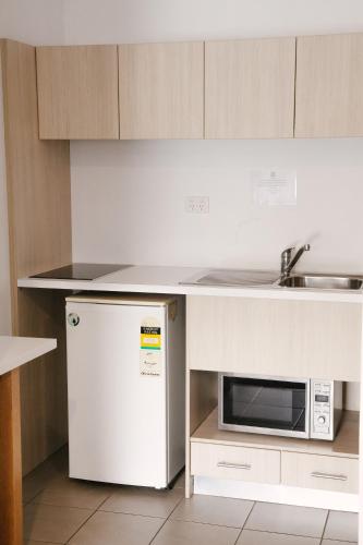 a kitchen with a white refrigerator and a microwave at Nagambie Waterfront Motel in Nagambie