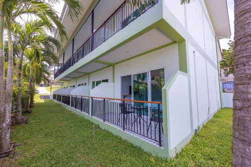 an exterior view of a building with palm trees at Karon Hotel at 22 in Karon Beach