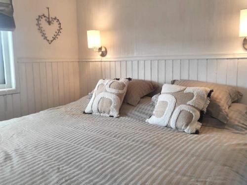 4 star holiday home in BORÅS في بوراس: سرير كبير ومخدات عليه في غرفة النوم