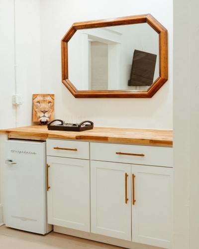 a bathroom with white cabinets and a mirror at Warner Hotel in Bisbee