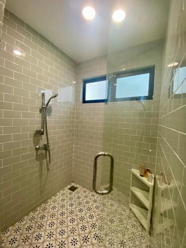 a bathroom with a shower and a tiled floor at Laman Abang Villa Homestay in Banting