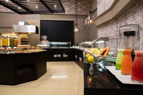 a restaurant with a counter with food on it at Krystal Satelite Maria Barbara in Mexico City