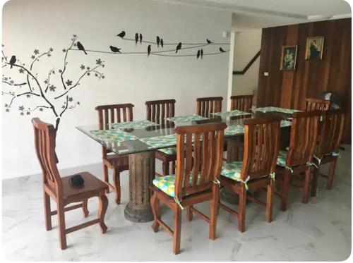 a dining room table and chairs with birds on a wall at Casa Valle Alto in Ciudad Valles