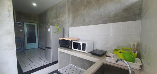 a kitchen with a microwave sitting on a counter at A small house next to the canal in Prachuap Khiri Khan