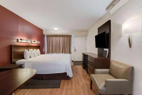 a hotel room with a bed and a television at Super 8 by Wyndham Deerfield - Northbrook in Deerfield