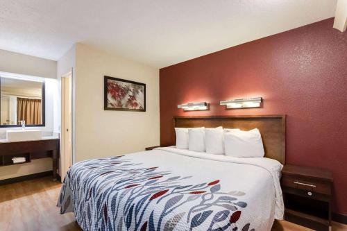 a hotel room with a large bed and a bathroom at Super 8 by Wyndham Deerfield - Northbrook in Deerfield