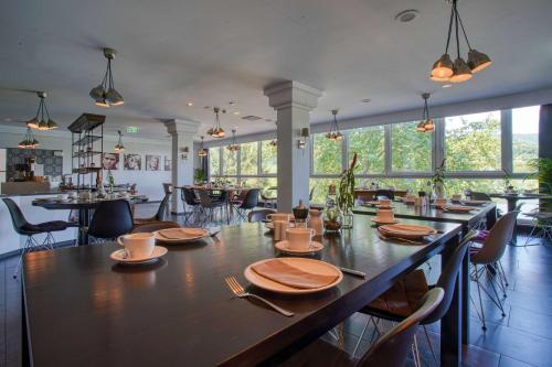 a dining room with a large wooden table and chairs at FourSide Plaza Hotel Trier, Trademark Collection by Wyndham in Trier