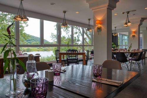 a dining room with a table and chairs and windows at FourSide Plaza Hotel Trier, Trademark Collection by Wyndham in Trier