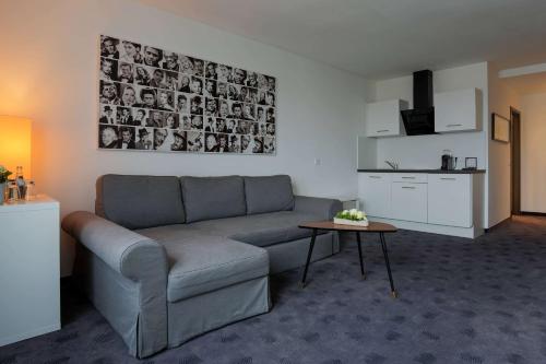 a living room with a couch and a table at FourSide Plaza Hotel Trier, Trademark Collection by Wyndham in Trier