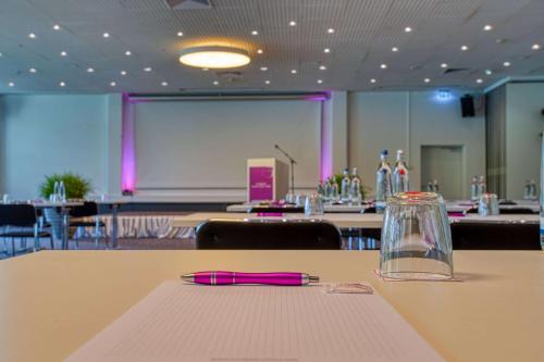 a conference room with a table with a pink pen on it at FourSide Plaza Hotel Trier, Trademark Collection by Wyndham in Trier
