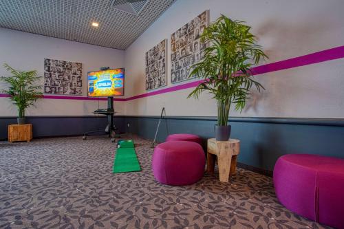 a room with a tv and a potted plant at FourSide Plaza Hotel Trier, Trademark Collection by Wyndham in Trier