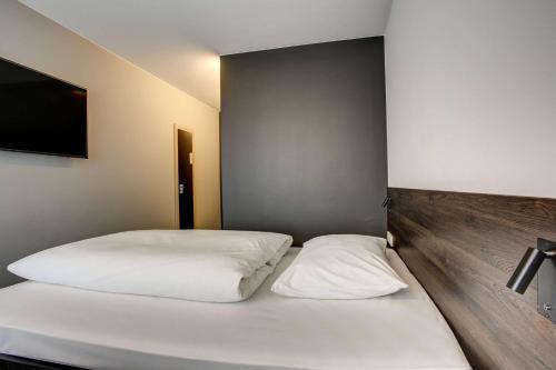 a bedroom with two beds with white sheets at Centro Park Hotel Stuttgart, Trademark Collection by Wyndham in Ostfildern