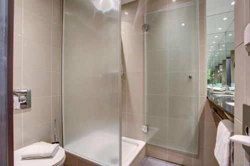a bathroom with a shower and a toilet at Centro Park Hotel Stuttgart, Trademark Collection by Wyndham in Ostfildern