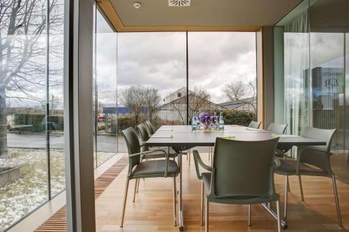 a dining room with a table and chairs at Centro Park Hotel Stuttgart, Trademark Collection by Wyndham in Ostfildern