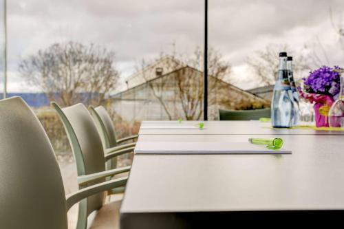 a white table with a pen and some chairs at Centro Park Hotel Stuttgart, Trademark Collection by Wyndham in Ostfildern