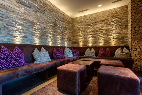 a bar with a leather couch with colorful pillows at Centro Hotel Stern Ulm City, Trademark Collection by Wyndham in Ulm