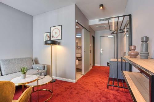a living room with a couch and a table at Centro Hotel Stern Ulm City, Trademark Collection by Wyndham in Ulm