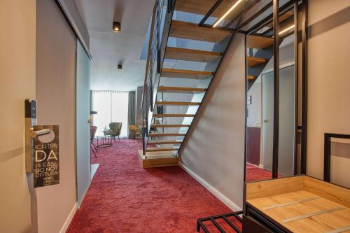 a staircase in a room with a red carpet at Centro Hotel Stern Ulm City, Trademark Collection by Wyndham in Ulm