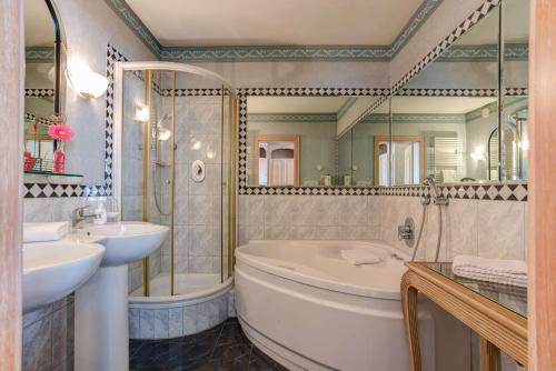 a bathroom with a tub and a sink and a mirror at Centro Hotel Stern Ulm City, Trademark Collection by Wyndham in Ulm