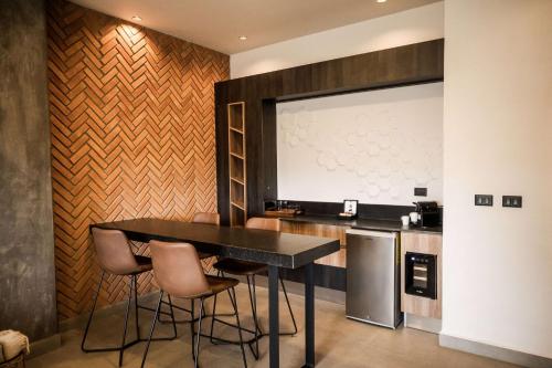 a kitchen with a table and chairs and a screen at Esplendor by Wyndham San Luis Potosi in San Luis Potosí
