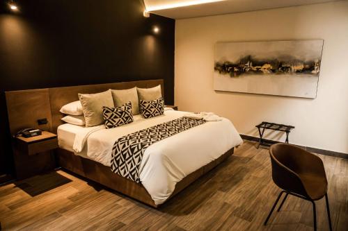 a bedroom with a large bed and a chair at Esplendor by Wyndham San Luis Potosi in San Luis Potosí