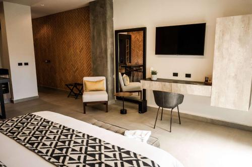 a bedroom with a bed and a desk and a tv at Esplendor by Wyndham San Luis Potosi in San Luis Potosí