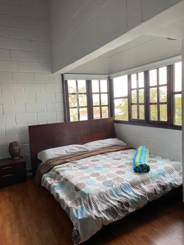a bedroom with a bed in a room with windows at Habitación lago calima Darien in Calima