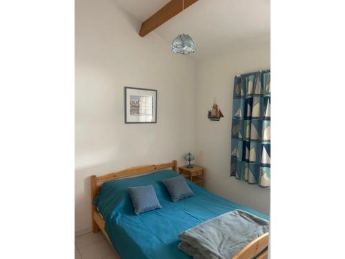 - une chambre dotée d'un lit avec des draps bleus dans l'établissement Maison avec Piscine Chauffée, Terrasse et Parking - Proche Plage et Forêt - FR-1-323-553, à Saint-Jean-de-Monts