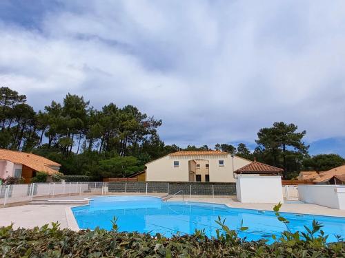 une villa avec piscine et une maison dans l'établissement Maison avec Piscine Chauffée, Terrasse et Parking - Proche Plage et Forêt - FR-1-323-553, à Saint-Jean-de-Monts