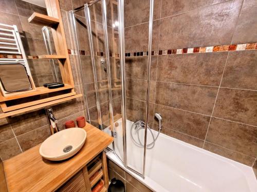 une salle de bain avec une douche, un lavabo et une baignoire dans l'établissement Appartement confortable avec terrasse et parking, proche centre, 4 personnes - FR-1-598-178, aux Gets