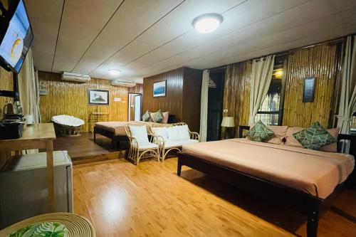 a hotel room with two beds and a living room at บ้านริมเลปากประ Banrimlay Pakpra in Phatthalung