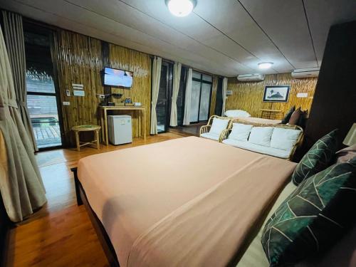 a large bed in a room with a tv at บ้านริมเลปากประ Banrimlay Pakpra in Phatthalung