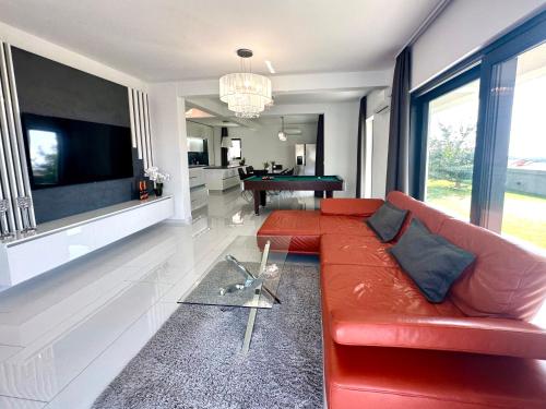 a living room with a red couch and a pool table at Fantasy Daydream Mansion in Novalja